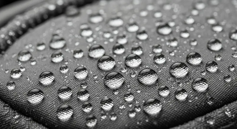 Water droplets beading on the surface of a PU-coated bag fabric, demonstrating water resistance