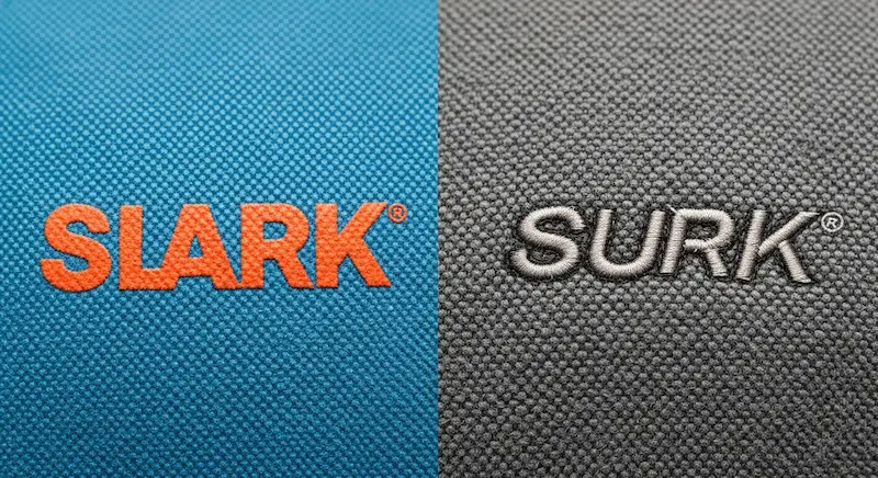 A close-up comparison of screen printing ink versus embroidery stitching on bag fabrics.
